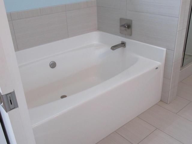 bathroom with a bathing tub and tile patterned floors