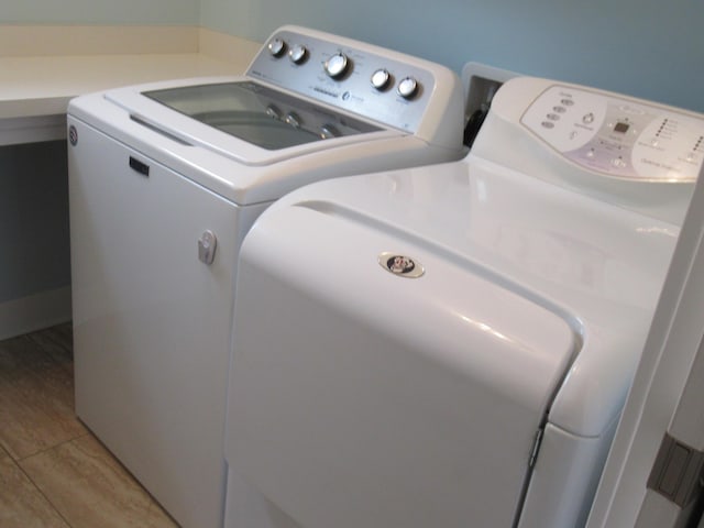 laundry room featuring washing machine and dryer and light hardwood / wood-style floors