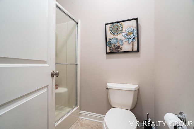 bathroom with tile patterned floors, toilet, and an enclosed shower