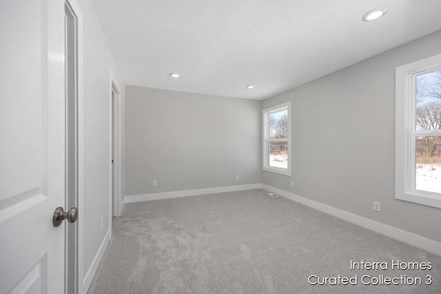 unfurnished room featuring recessed lighting, light carpet, and baseboards