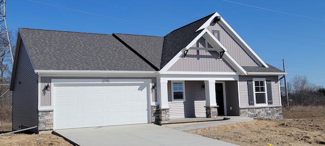 view of front of house with concrete driveway, a garage, stone siding, and roof with shingles