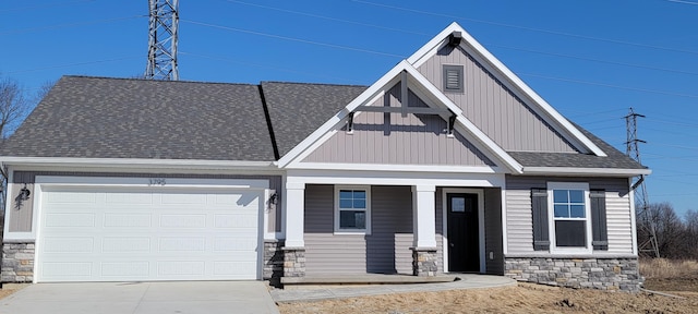 craftsman inspired home featuring stone siding, a garage, driveway, and roof with shingles