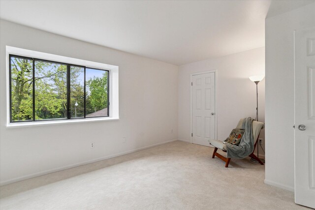 unfurnished room featuring light colored carpet and baseboards