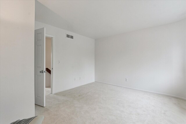 unfurnished room featuring light carpet and baseboards