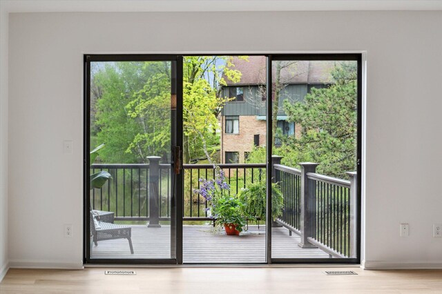 doorway to outside featuring wood finished floors and baseboards