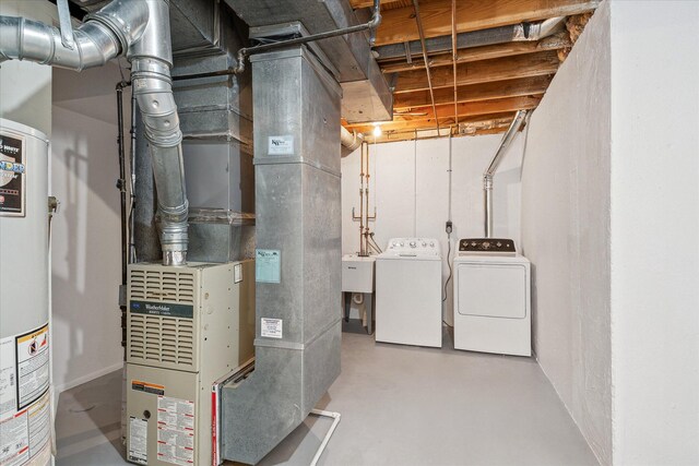 utility room featuring washing machine and clothes dryer, heating unit, and water heater