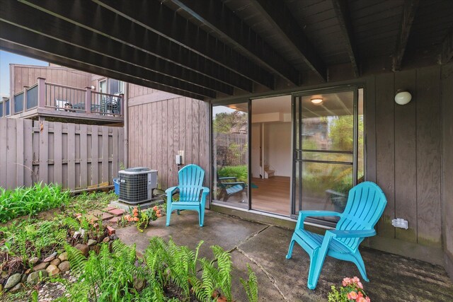 view of patio / terrace featuring central air condition unit and fence