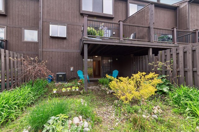 back of property with fence and central AC
