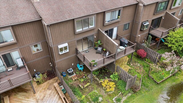 rear view of property with roof with shingles, central AC, a deck, and fence