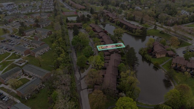 aerial view of property and surrounding area featuring a nearby body of water and nearby suburban area