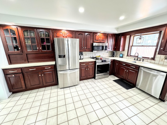 kitchen with tasteful backsplash, appliances with stainless steel finishes, and sink