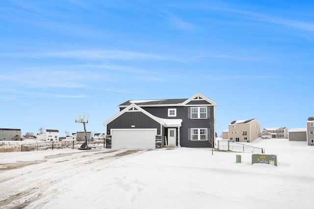 snow covered back of property featuring a garage