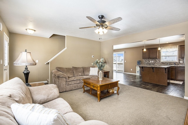 living room featuring ceiling fan and dark hardwood / wood-style flooring