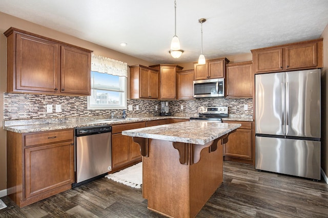 kitchen with a breakfast bar, a center island, dark hardwood / wood-style flooring, pendant lighting, and stainless steel appliances