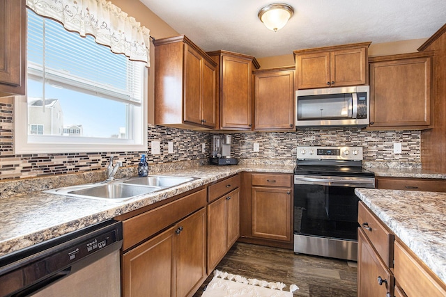 kitchen featuring appliances with stainless steel finishes, dark hardwood / wood-style floors, sink, and backsplash