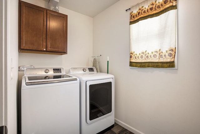 washroom with cabinets, washer and dryer, and dark wood-type flooring