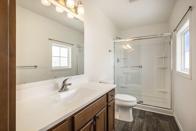 bathroom with wood-type flooring, toilet, a shower with door, and vanity