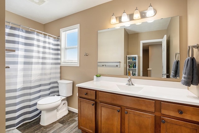 bathroom with vanity, toilet, and hardwood / wood-style floors