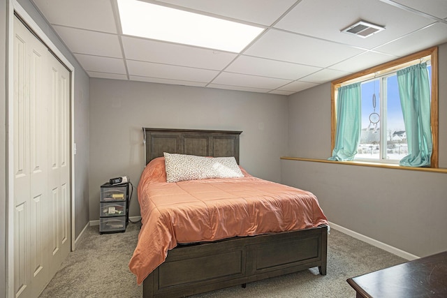 bedroom featuring carpet, a paneled ceiling, and a closet