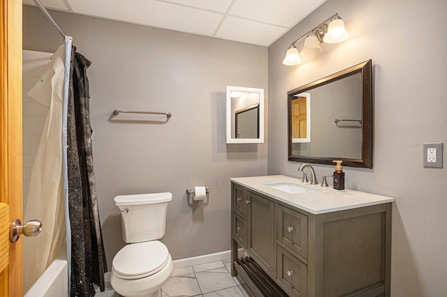 full bathroom featuring vanity, toilet, shower / bath combo with shower curtain, and a drop ceiling