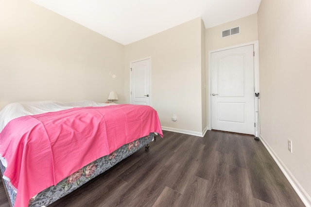 bedroom with dark hardwood / wood-style flooring