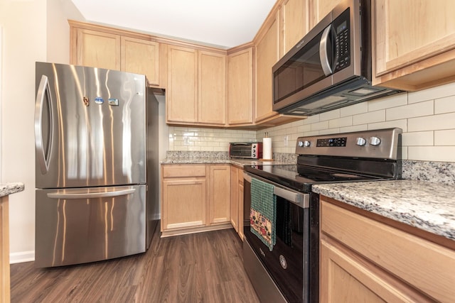 kitchen with light stone counters, dark hardwood / wood-style flooring, stainless steel appliances, and light brown cabinets