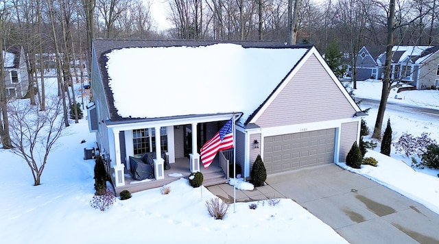 view of front of home featuring central AC unit, a garage, and covered porch