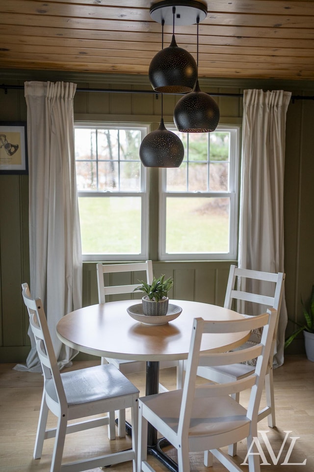 dining space featuring light wood-type flooring and wood ceiling