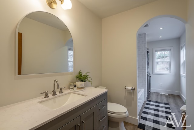 bathroom featuring toilet, recessed lighting, wood finished floors, vanity, and baseboards