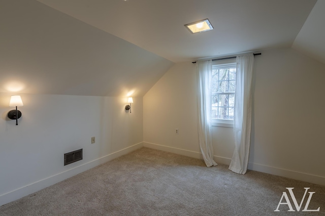 additional living space featuring carpet, visible vents, lofted ceiling, and baseboards