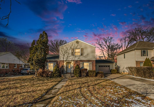 front of property with a garage and a yard