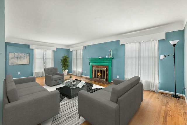 living room featuring a brick fireplace and light hardwood / wood-style flooring