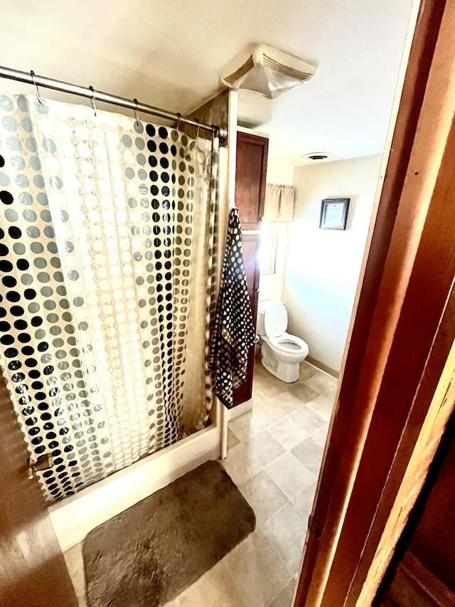 bathroom featuring curtained shower and toilet