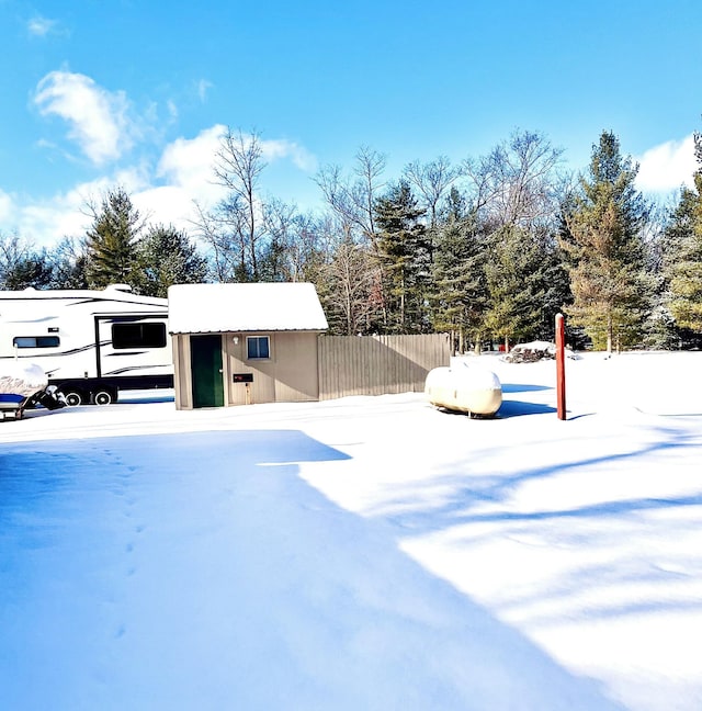 yard layered in snow featuring an outdoor structure