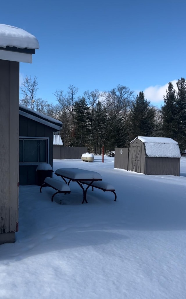 yard covered in snow with a storage unit