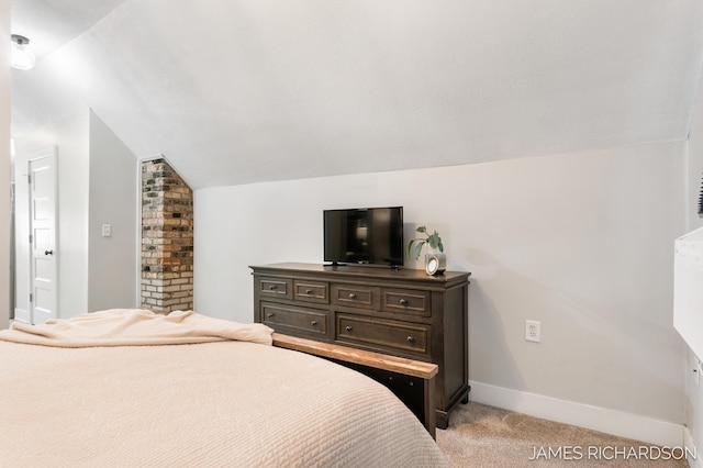 bedroom with lofted ceiling, light colored carpet, and baseboards