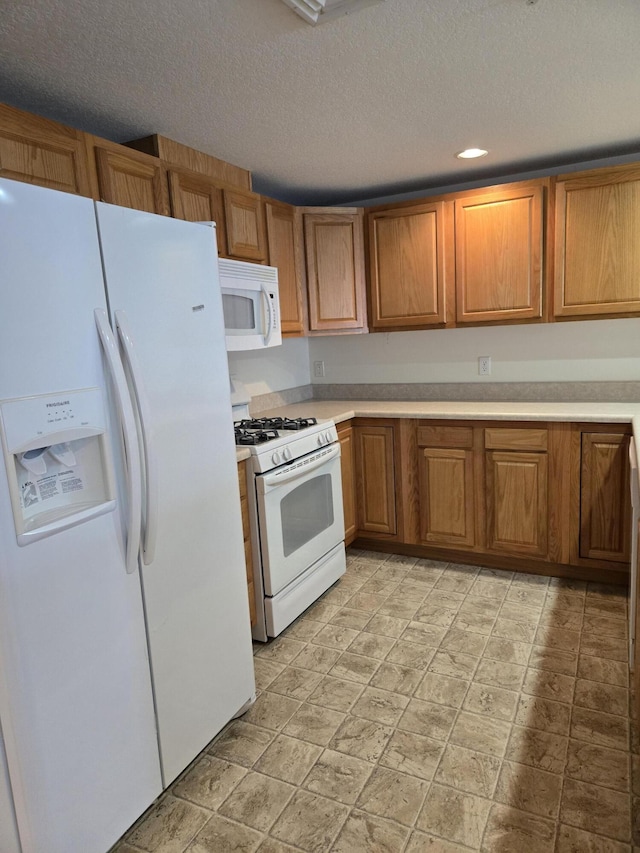 kitchen with white appliances and a textured ceiling