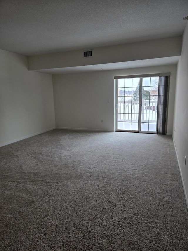 carpeted spare room featuring a textured ceiling