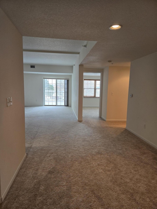 unfurnished room featuring light colored carpet and a textured ceiling