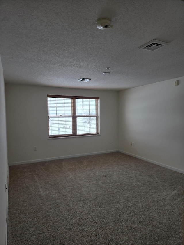 carpeted spare room with a textured ceiling