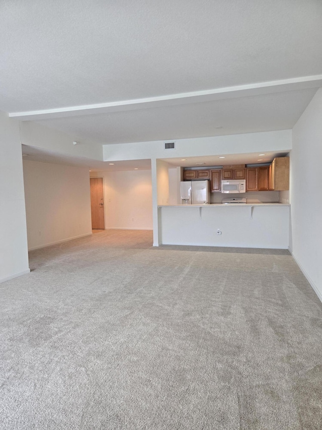 unfurnished living room featuring light carpet