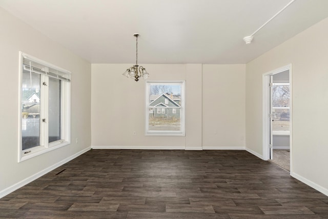 unfurnished dining area with dark hardwood / wood-style floors and a notable chandelier