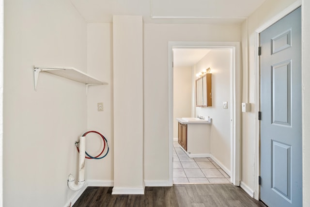 clothes washing area featuring wood-type flooring and sink