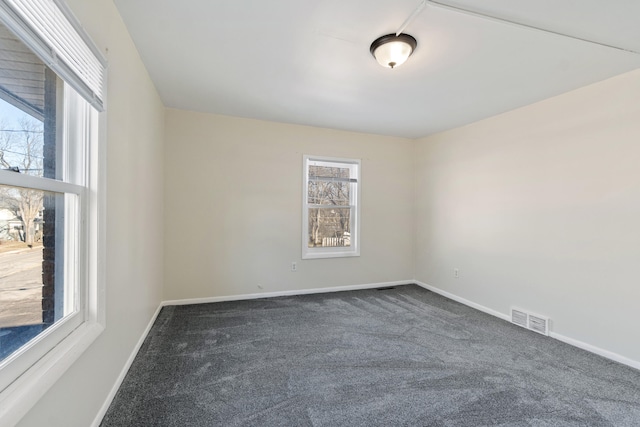 spare room with dark colored carpet