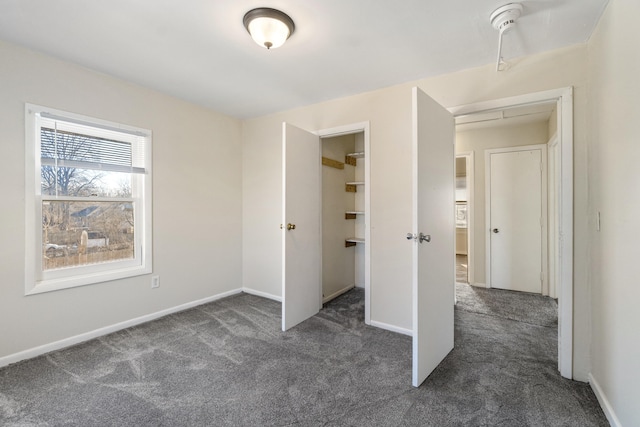 unfurnished bedroom featuring dark carpet and a closet