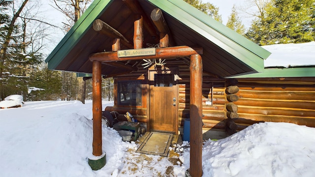 6919 E Free Soil Rd, Free Soil, MI 49411 - snow covered property entrance featuring log siding
