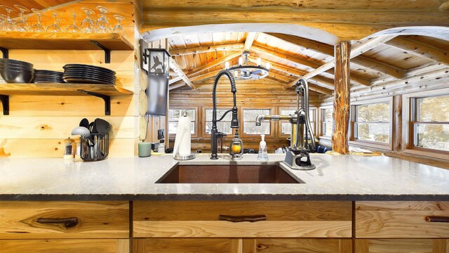 6919 E Free Soil Rd, Free Soil, MI 49411 - kitchen featuring wood ceiling, lofted ceiling with beams, dark stone countertops, rustic walls, and a sink