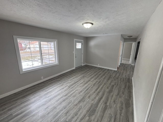 entryway with a textured ceiling and dark hardwood / wood-style flooring