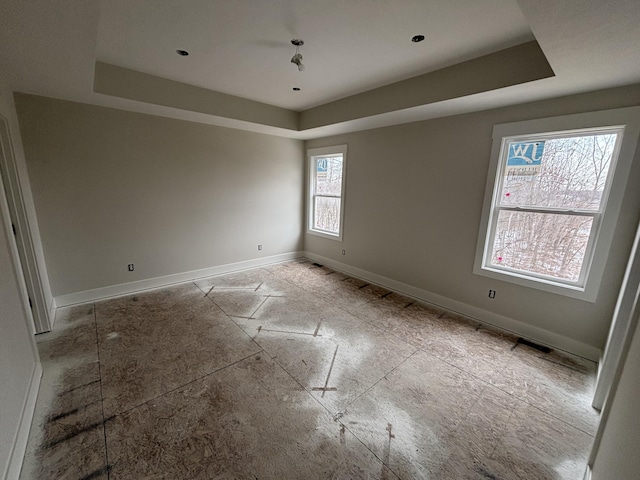 spare room with a tray ceiling