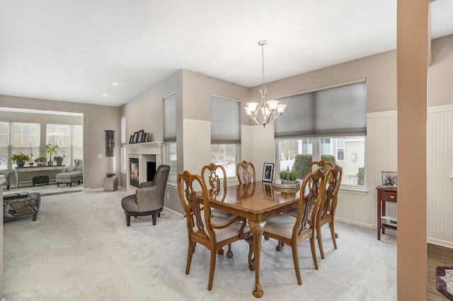 dining area with plenty of natural light, light carpet, and a notable chandelier